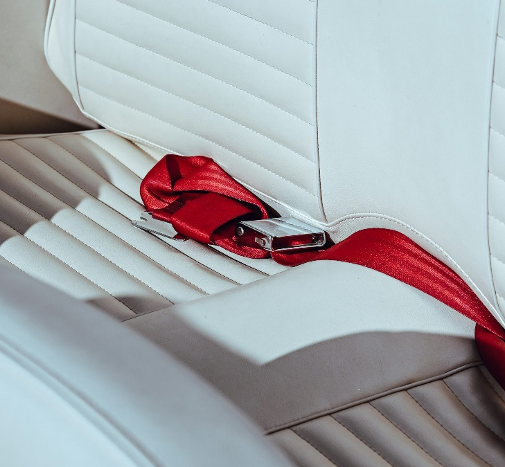 A red seatbelt on a white seat