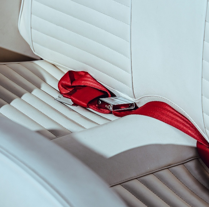 A red seatbelt on a white seat