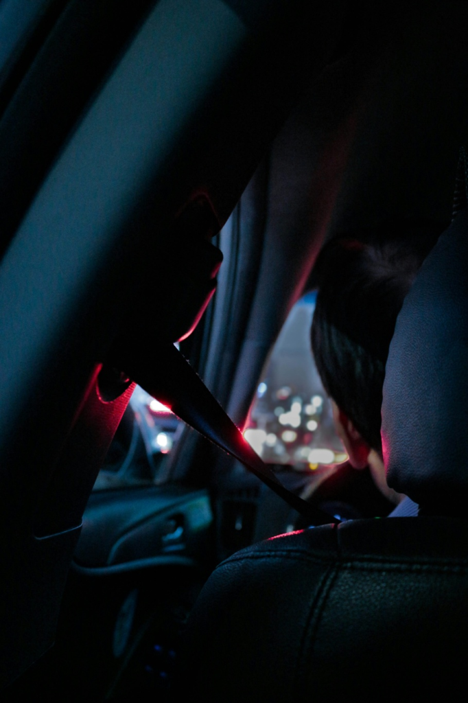 A man in the front seat of a car wearing a seatbelt