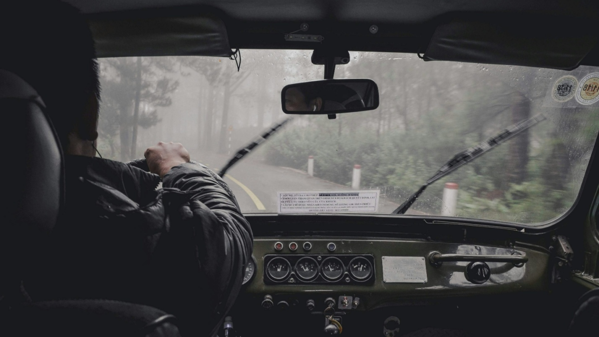 A man driving a car in the rain