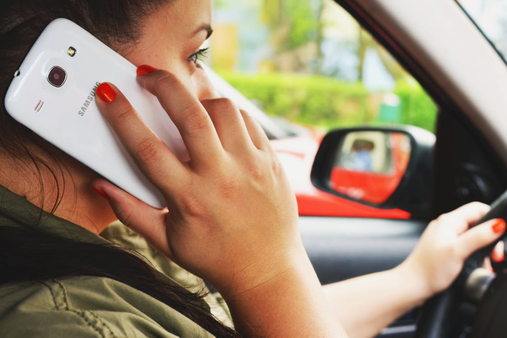Woman driving a car while talking on a smartphone